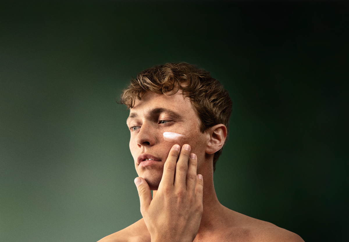 Ein Mann cremt sein Gesicht mit der lavera Men sensitive Feuchtigkeitscreme ein.