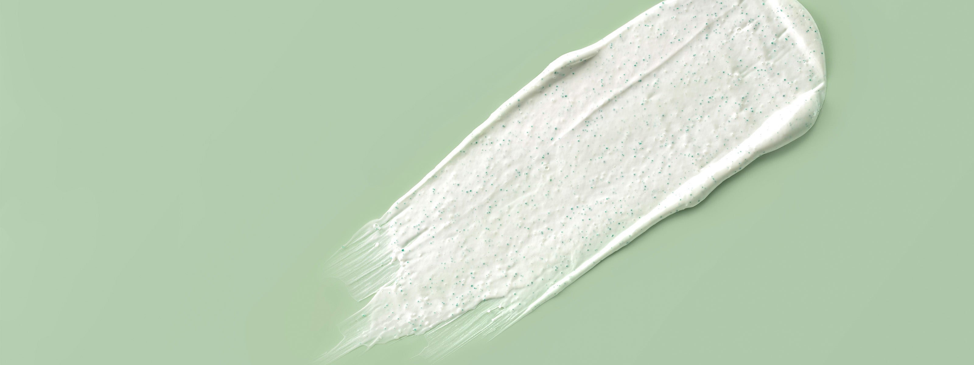 Creme Textur auf grünem Hintergrund