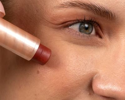Multi Balm wird auf die Wange aufgetragen