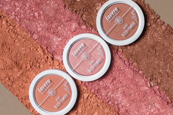 Drei lavera Velvet Blush Powder auf zerkrümeltem Puder